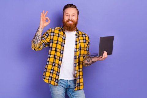 Mann mit Laptop in der Hand. Mit der anderen Hand zeigt er "sehr gut"