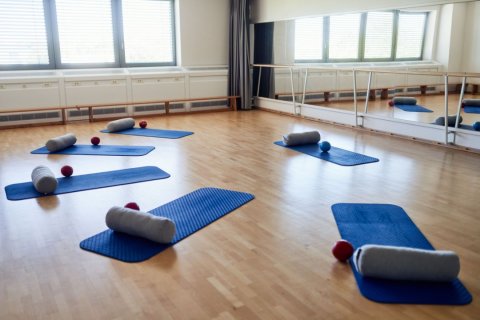 Ein Halbkreis aus Yogamatten im Bewegungsraum der VHS Essen. 