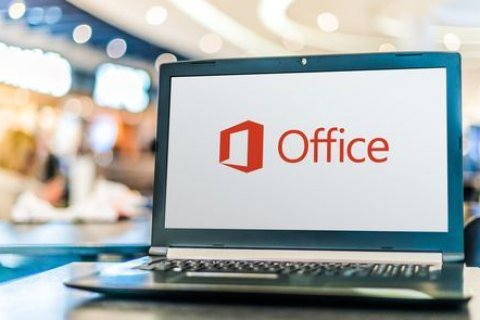 Auf einem Tisch steht ein Laptop der das Office Logo zeigt.